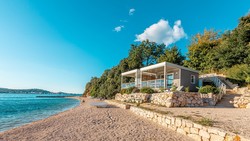 Plaža je prodnata in peščena, del je namenjen psom.